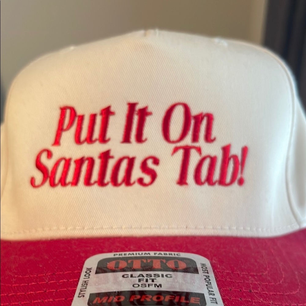 White and Red Cap with 'Put It On Santas Tab!'